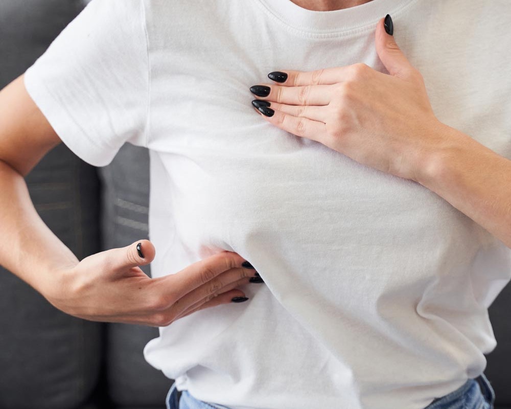 Woman gingerly touching chest