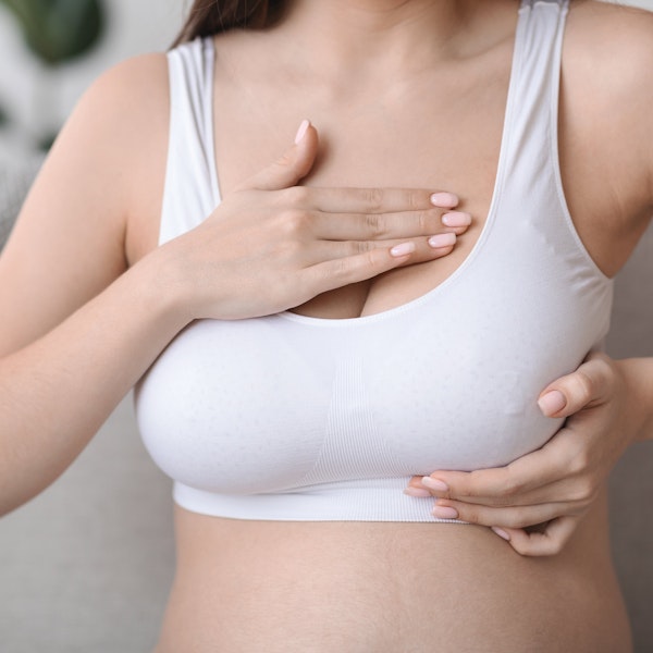 Closeup of woman checking breasts after breast cancer and reconstructive breast surgery