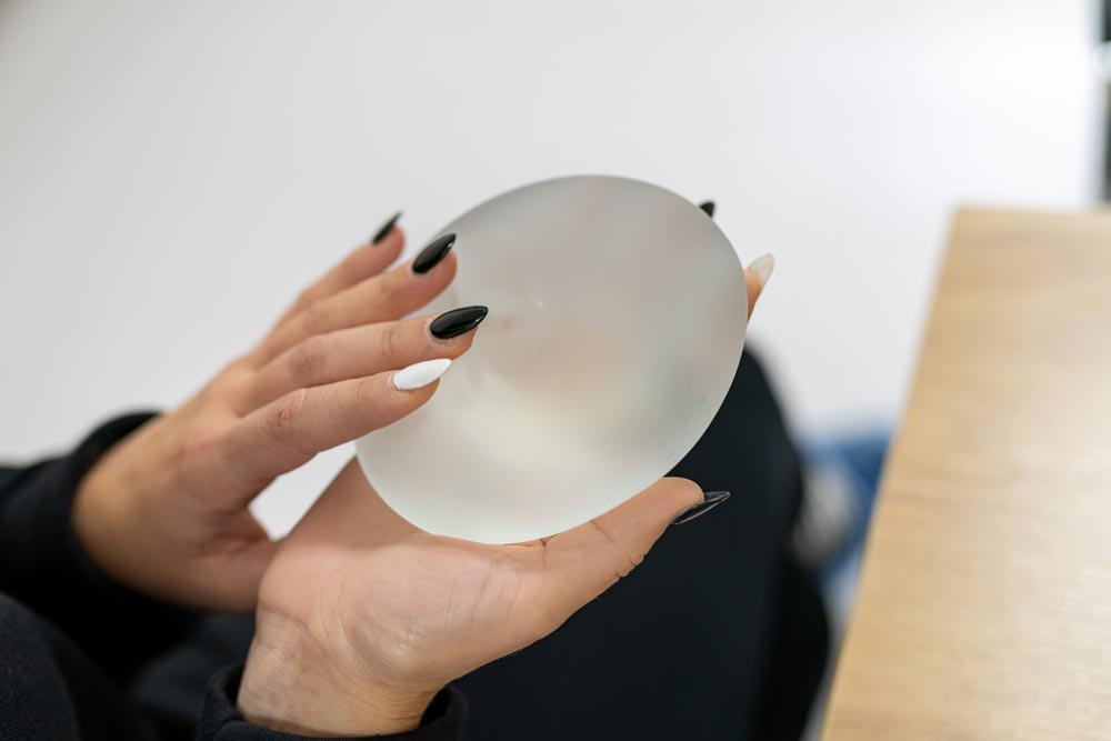 Woman holding breast implant
