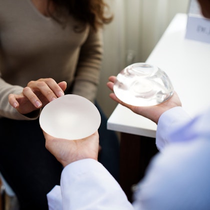 Woman looking at saline and silicone breast implants