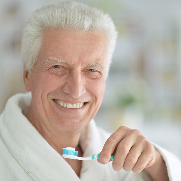 Older man smiling before brushing teeth