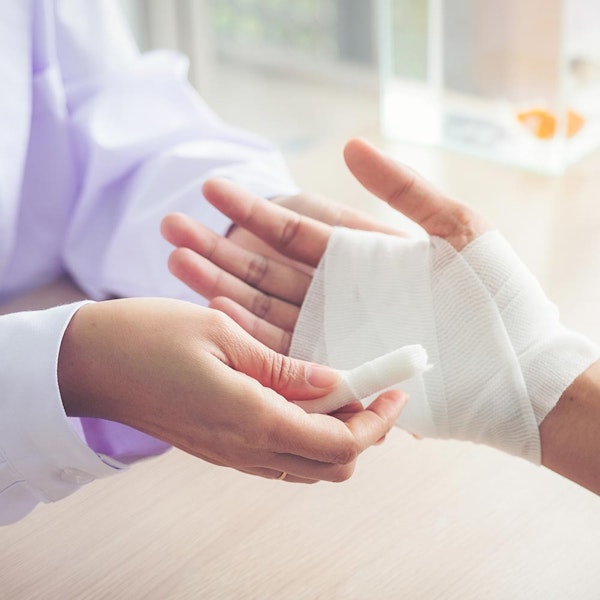 Doctor dressing a patient's hand after surgery