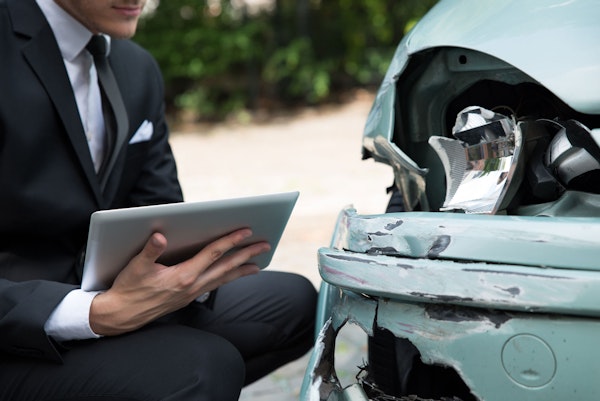 Lawyer reviewing accident damage to a car