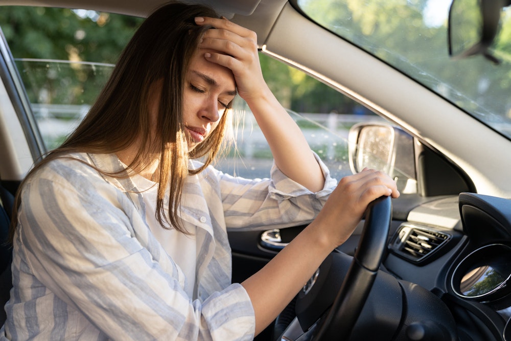 Woman holding head after car accident