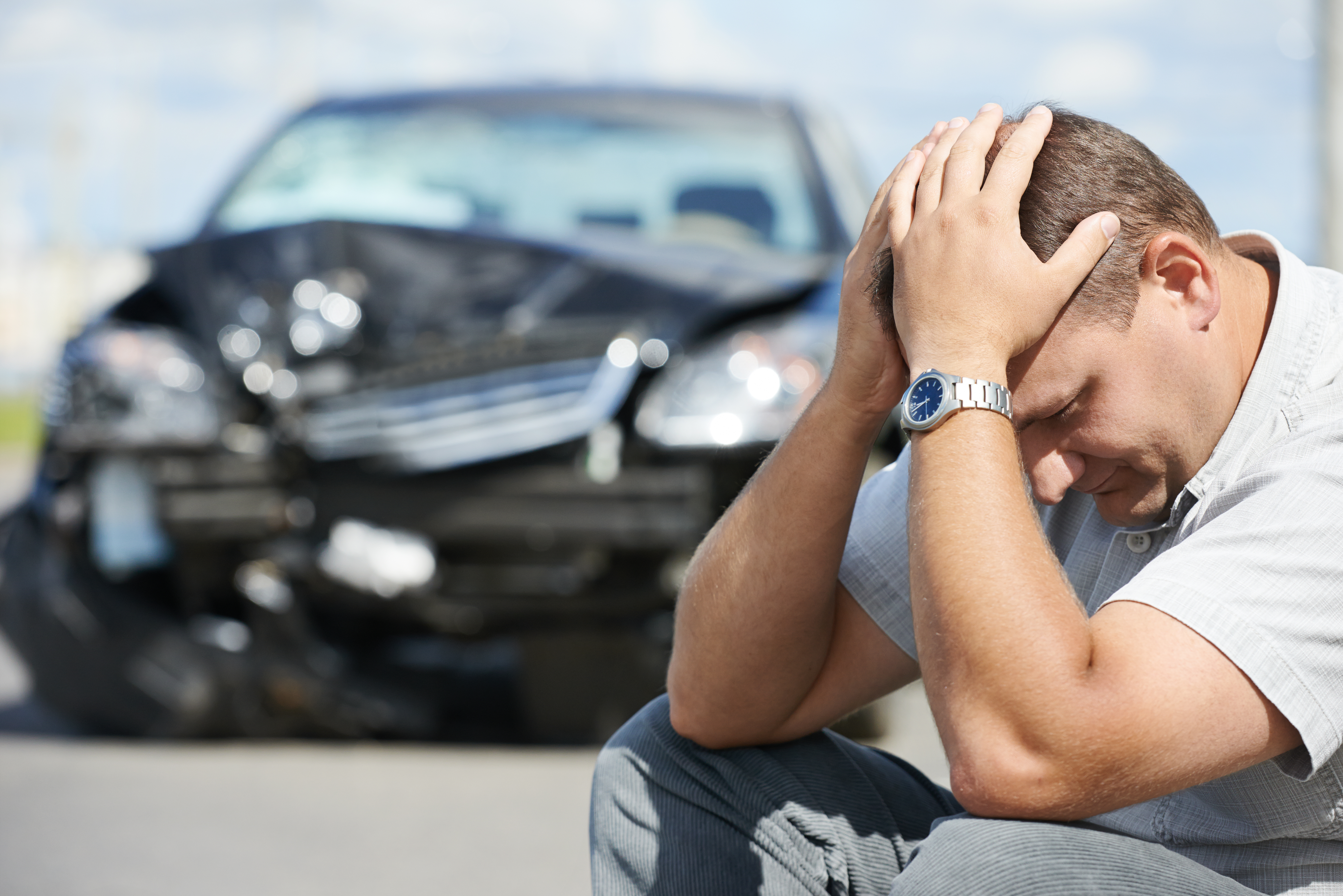 Man holding head in hands after car accident