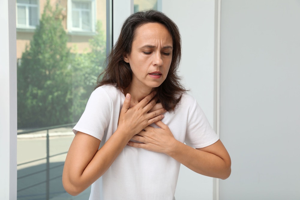 woman holding hands to sternum