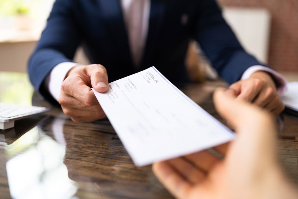 Man giving compensation check