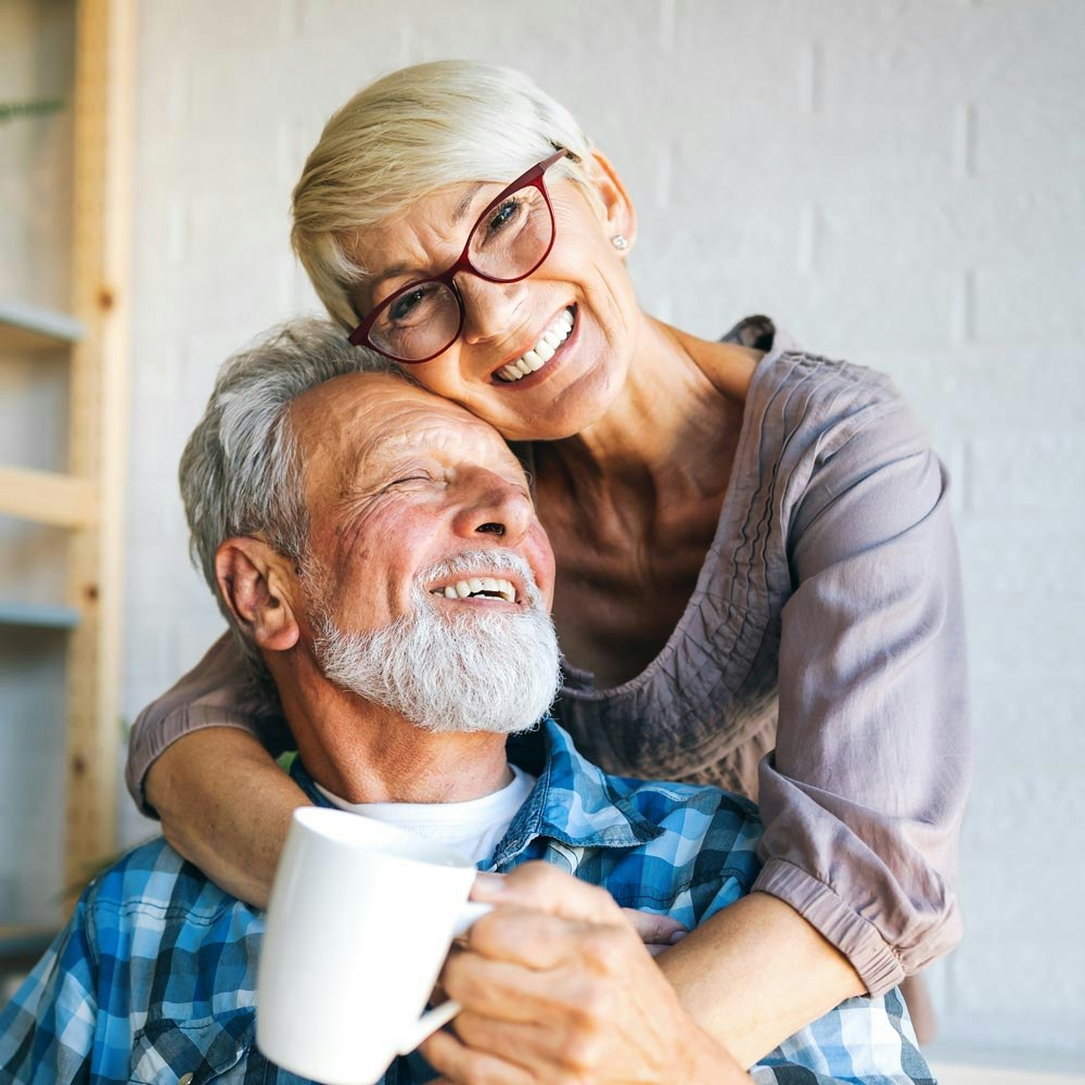 Smiling mature couple with dental implants