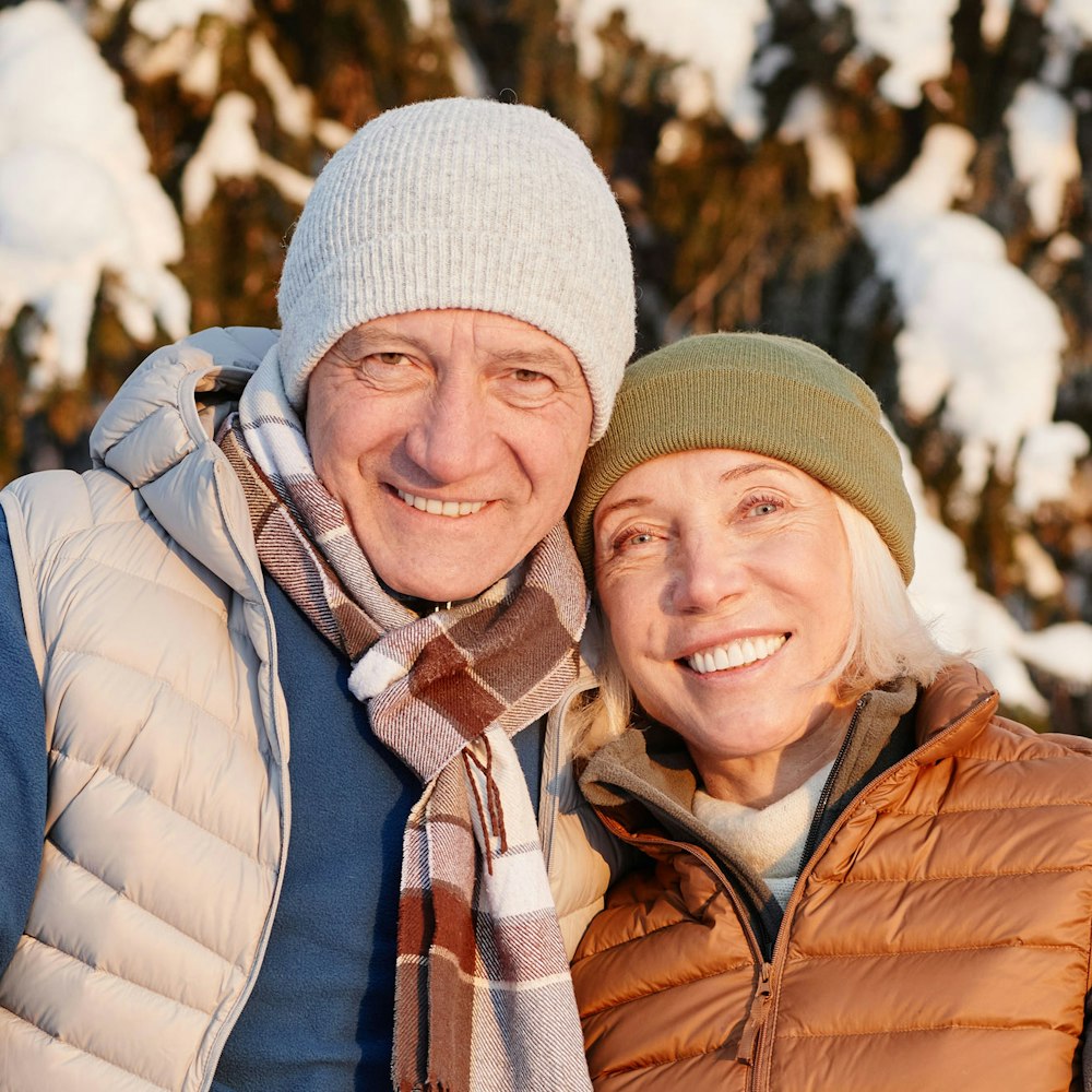 Smiling elderly couple wearing snow gear