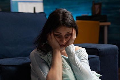 distressed young woman sitting on floor