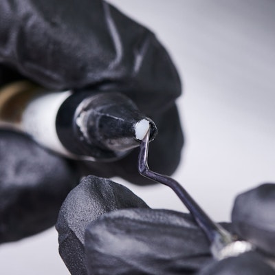 dentist prepping tooth-colored material for dental bonding procedure