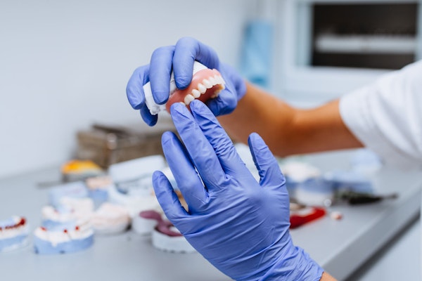 Dentist holding a denture prosthetic