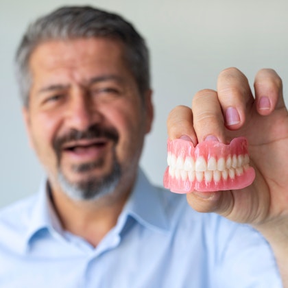 Man holding up dentures