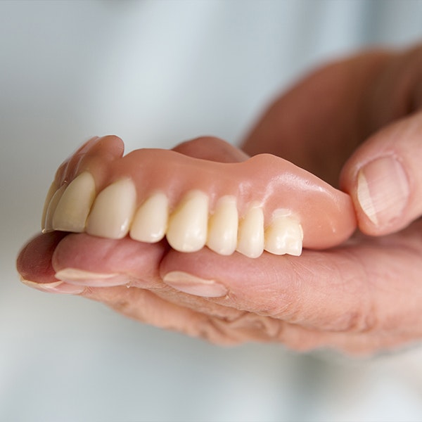Person holding denture