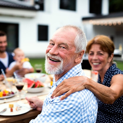 Three older adults enjoying their time together at what looks to be a summer BBQ