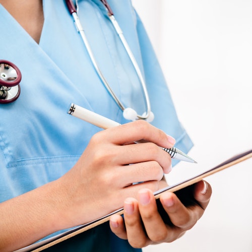 Doctor writing diagnosis on clipboard