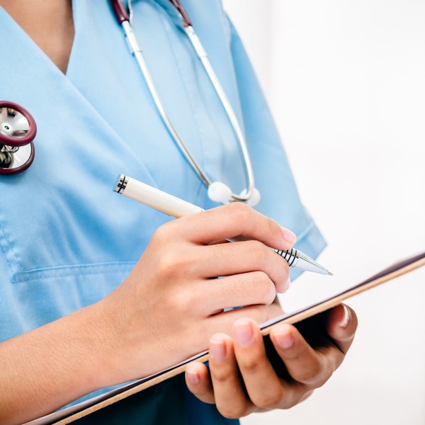 Nurse with patient information on clipboard