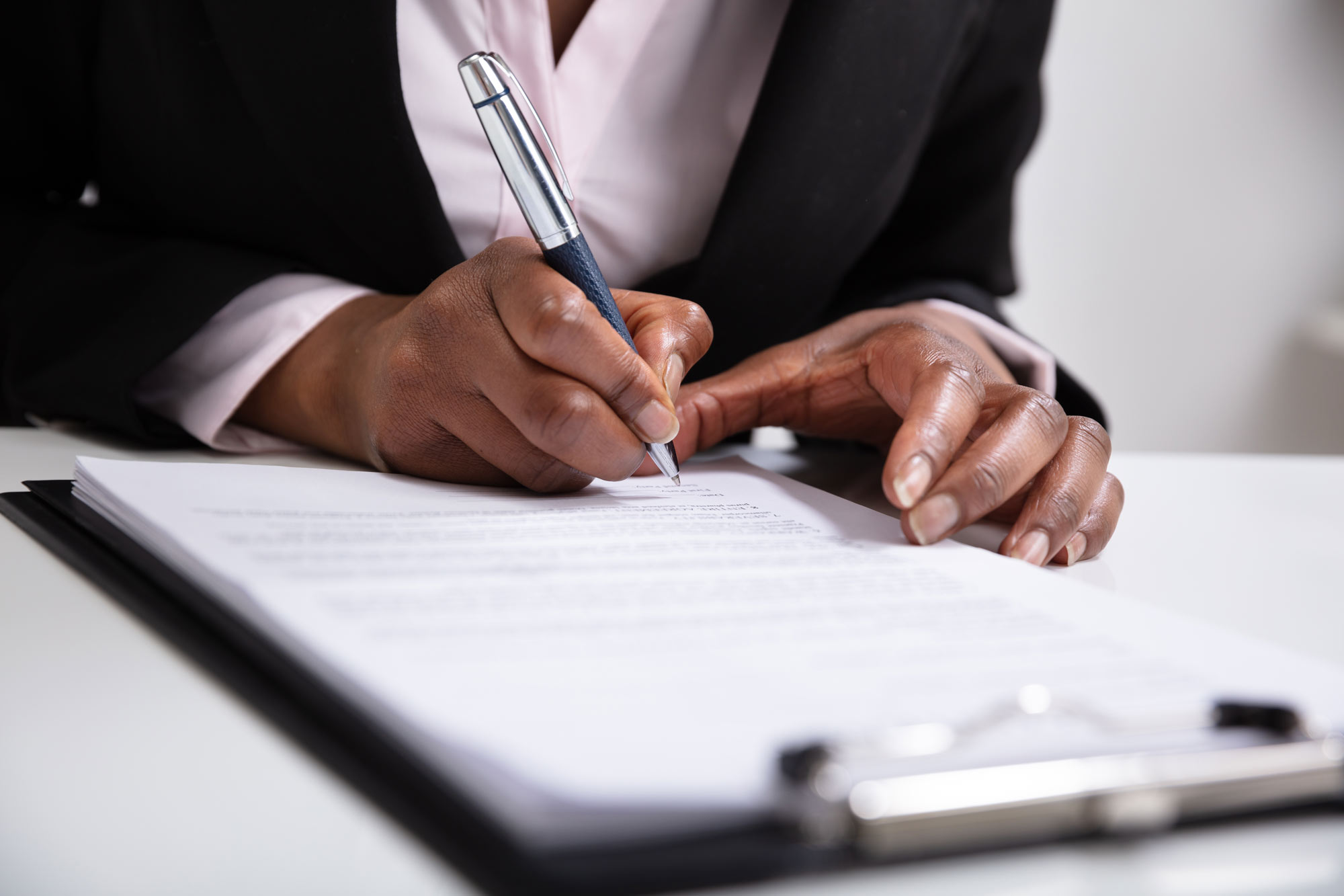 A closeup of someone signing paperwork