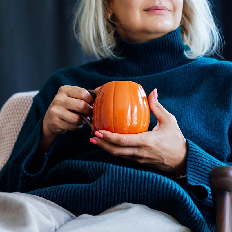 Mature woman holding an orange mug