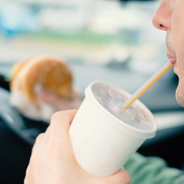 Man eating and drinking while driving