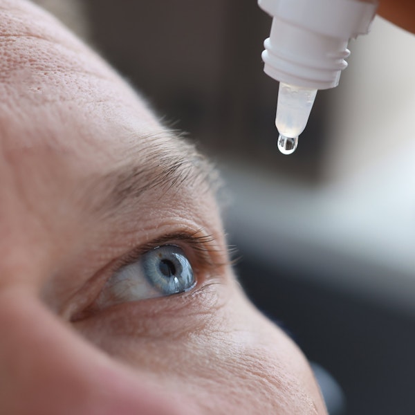 Mature man putting eyedrops into eye