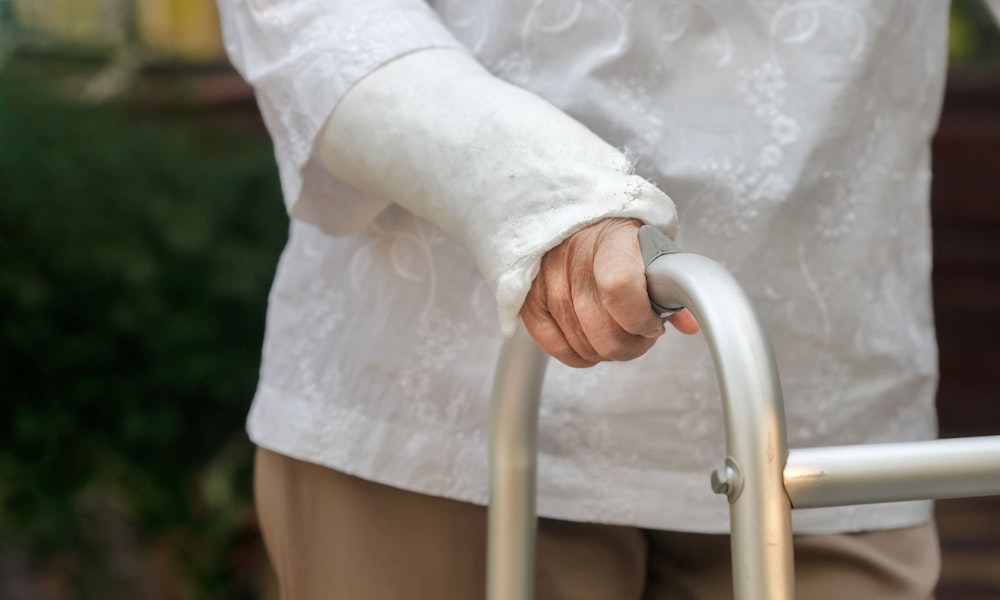 Elderly woman with injured arm and walker
