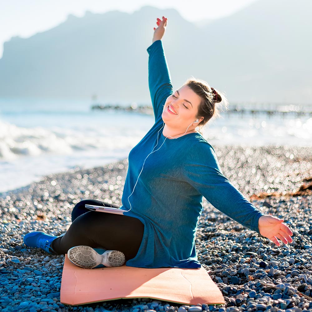 Happy woman on the beach listening to music