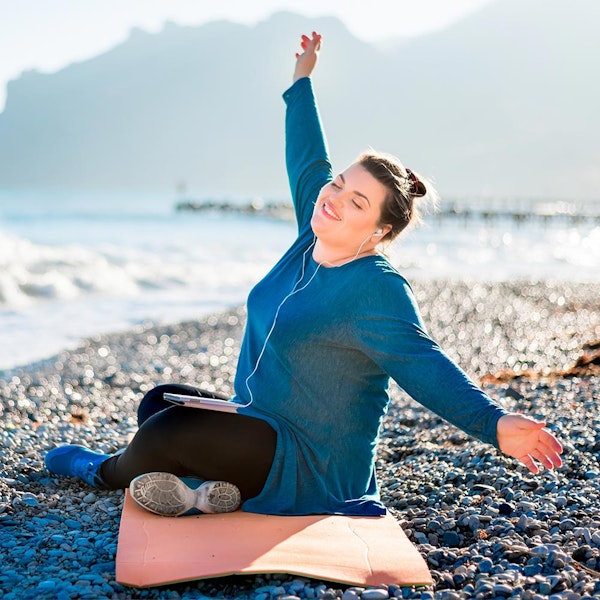 Happy woman on the beach listening to music