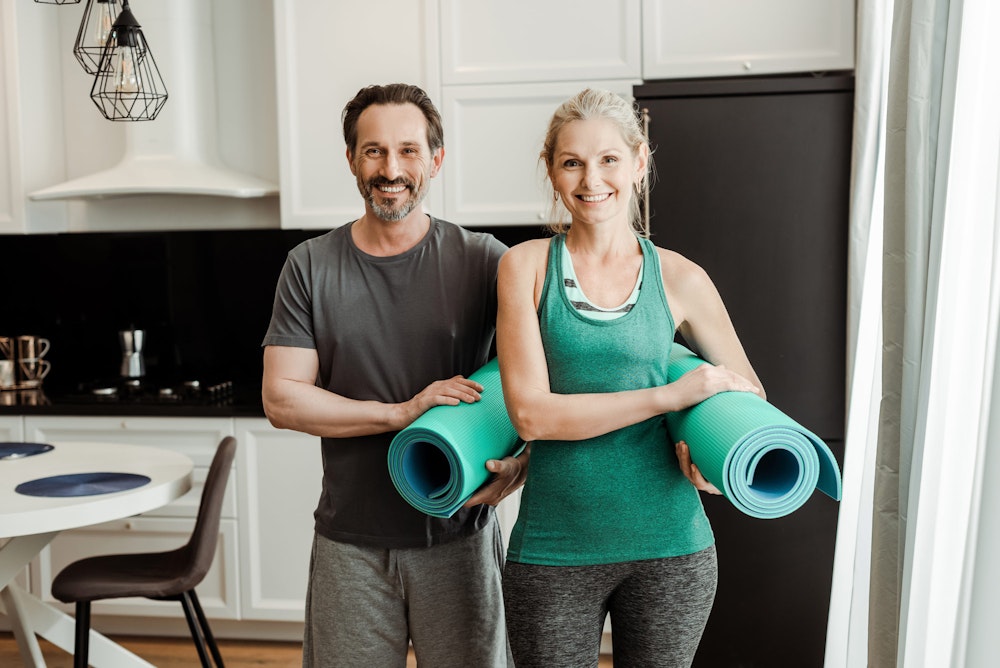 couple holding yoga mats