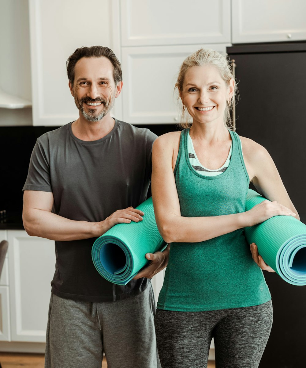 couple holding yoga mats