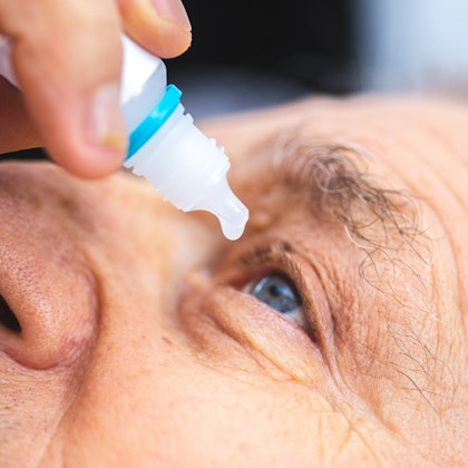 Patient administering eye drops