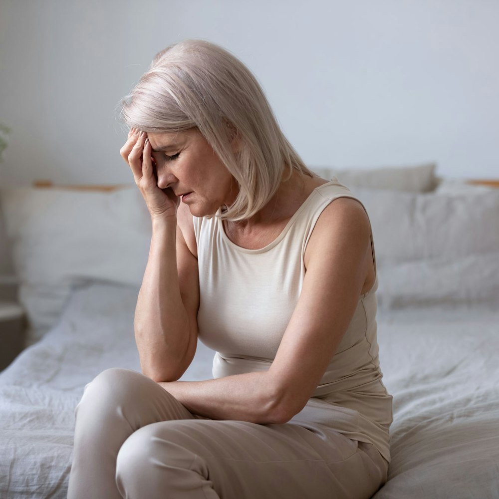 Woman holding head in hands