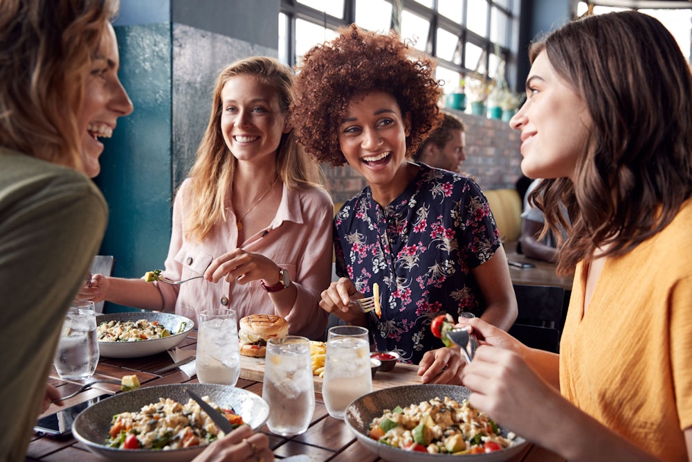 Friends eating a meal together with beautiful smiles