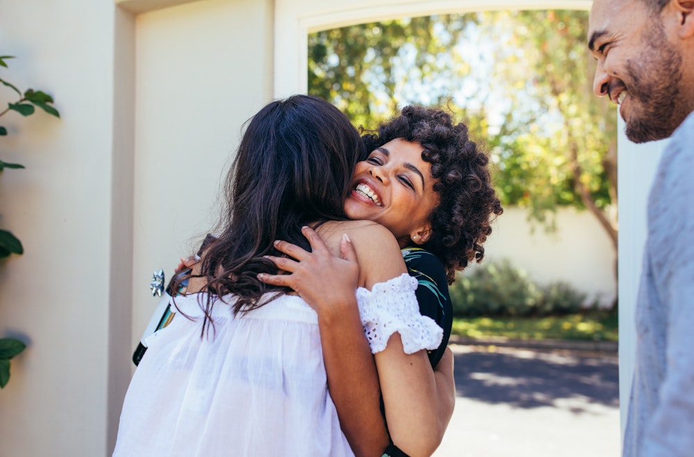 Pregnant woman greeting happy couple