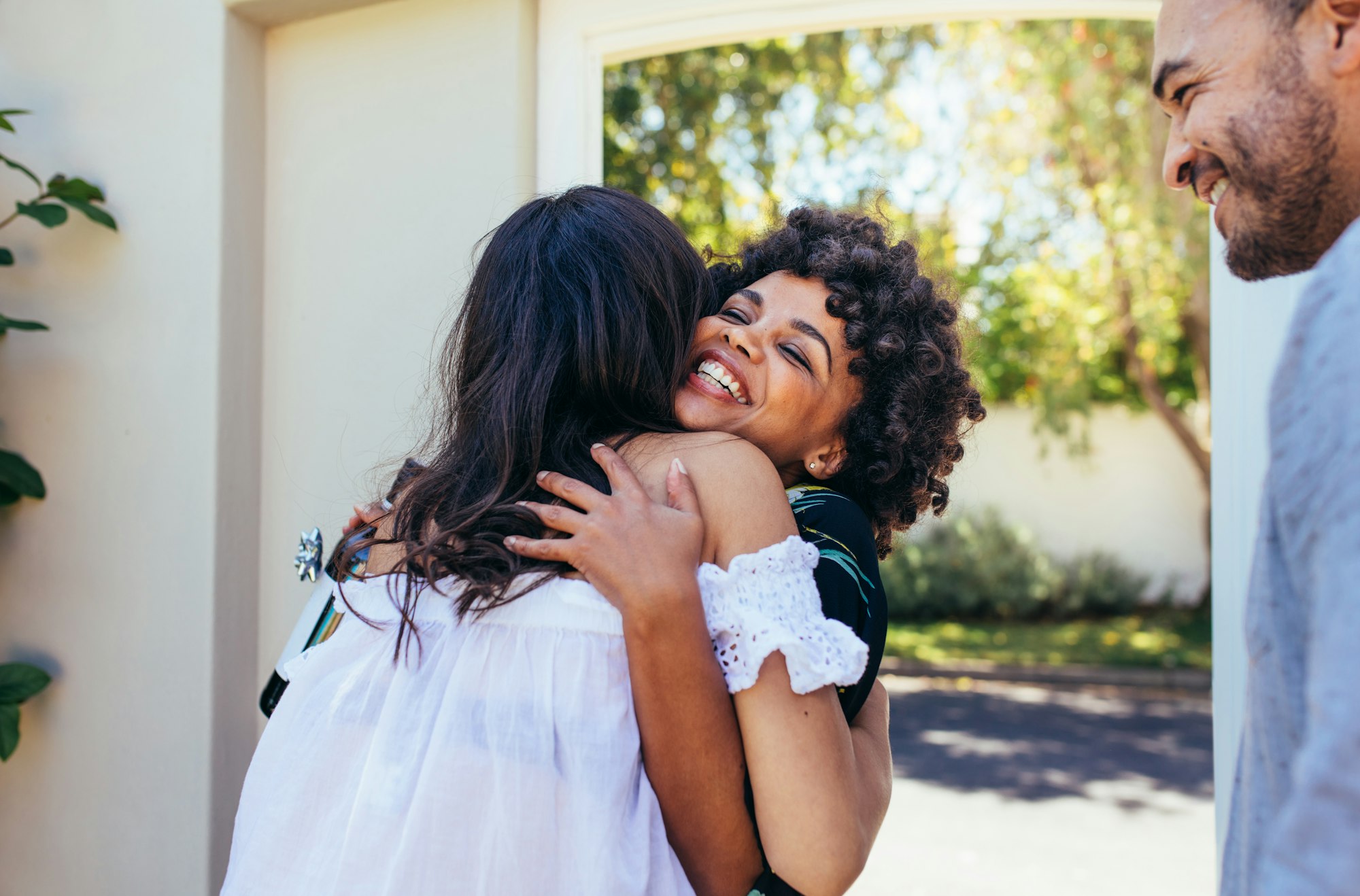 Pregnant woman greeting happy couple