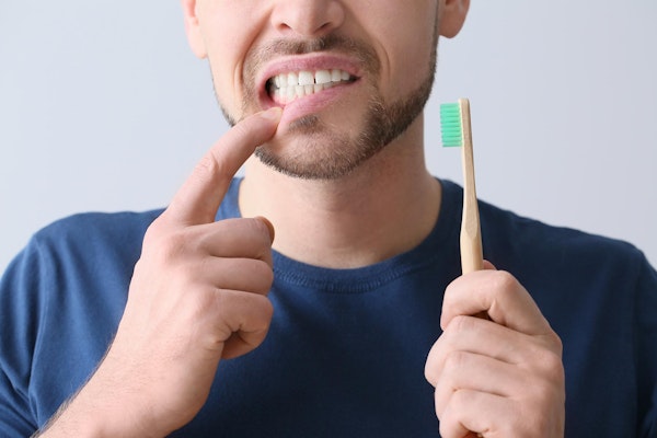 Man with gum inflammation as he brushes teeth