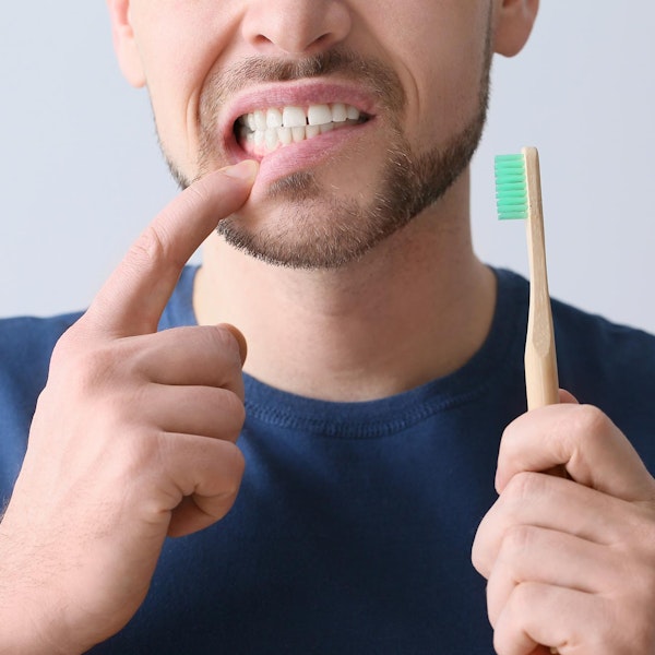 Man with gum inflammation as he brushes teeth