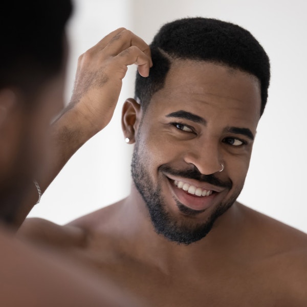 Man smiling while looking at facelift in mirror