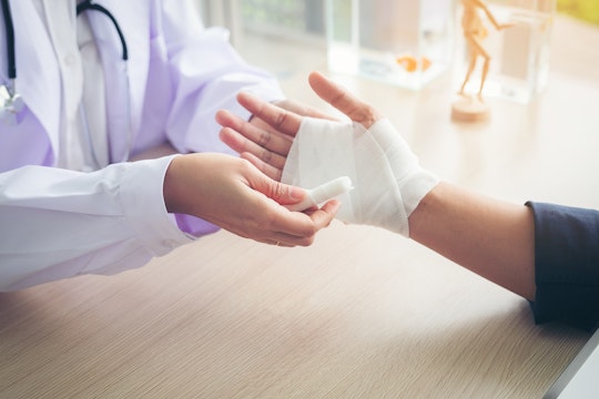 Doctor examining patient's bandaged wrist
