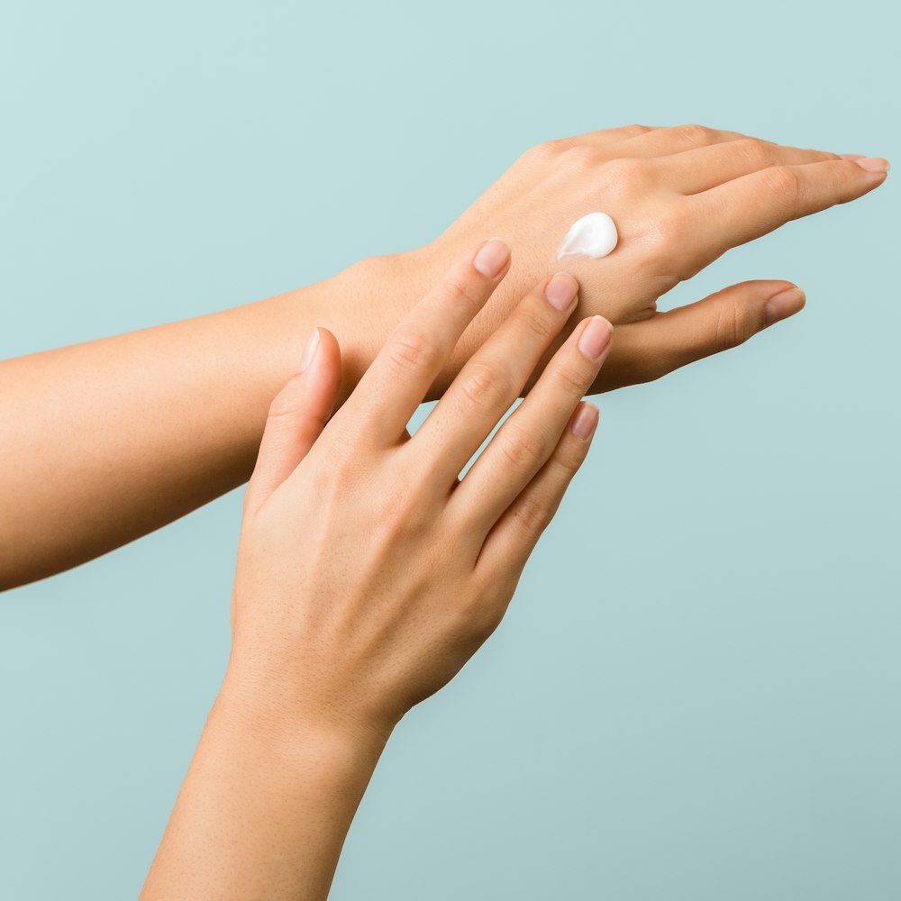 Woman applying cream to the back of hands