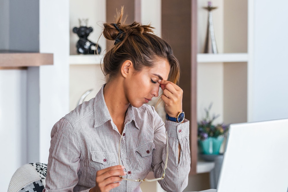 Woman holding head with a headache