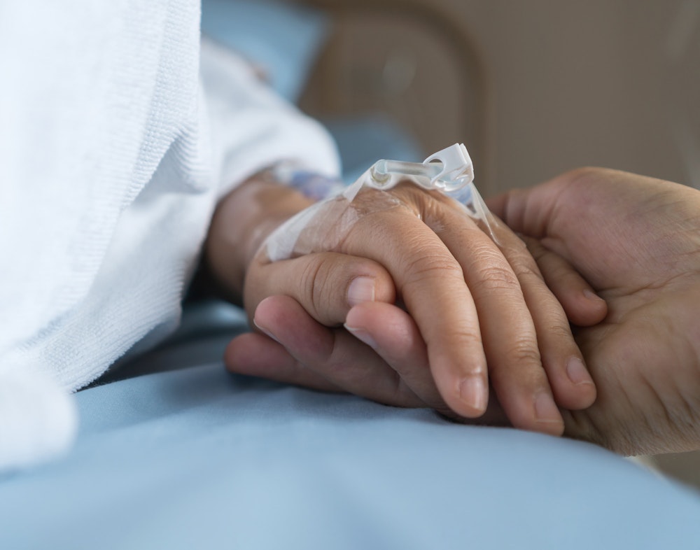 Patient holding hand of loved one