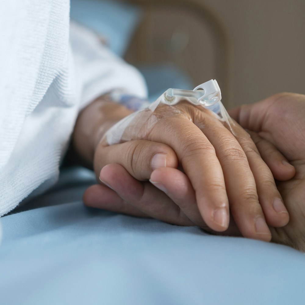 Loved one holding patient's hand