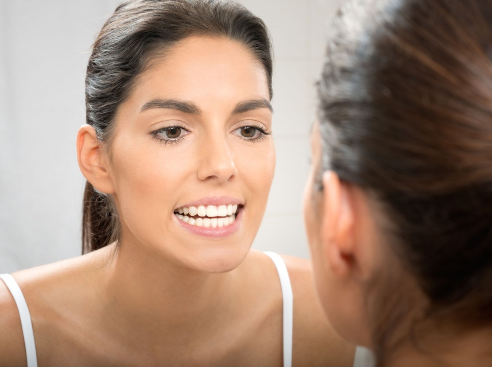 A woman smiling in the mirror.