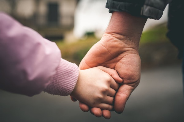 Adult and small child holding hands