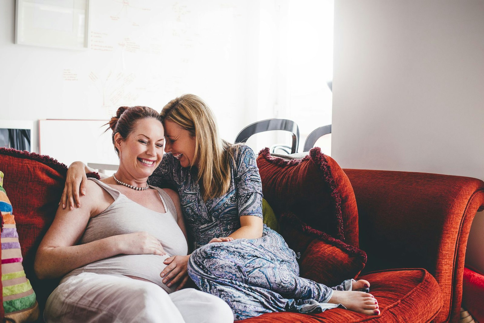 Lesbian couple curled up on couch together