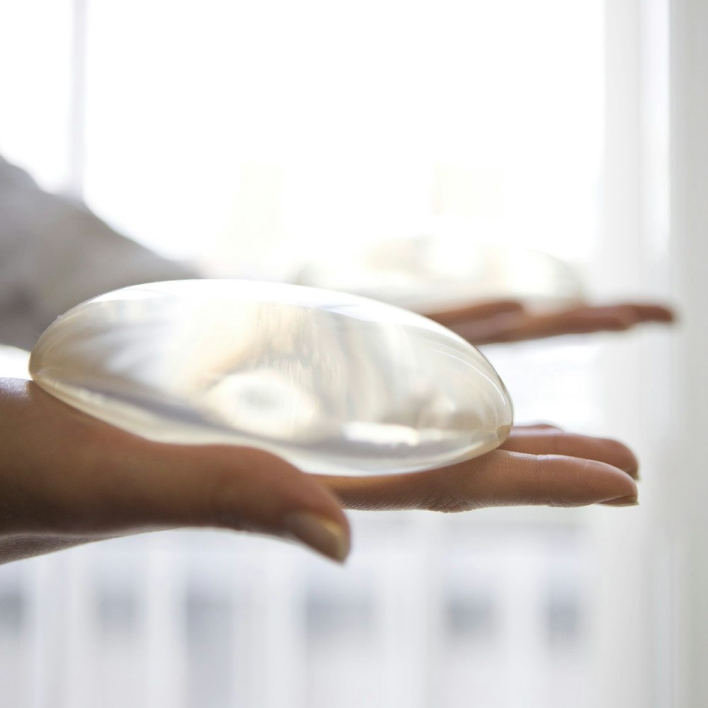 Person holding breast implant in hand