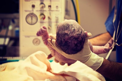 Doctor holding newborn