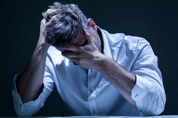 Man holding head in hands