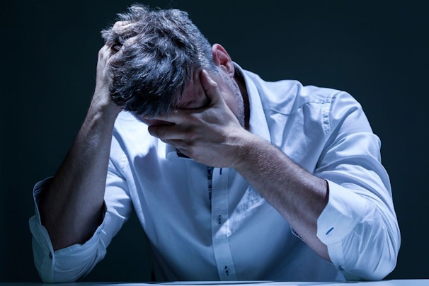 image of man holding head